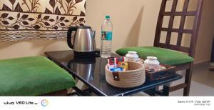 a table with a coffee maker and two chairs at Sky park homestay in Yercaud