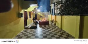 a person with a dog sitting on a checkered floor at Sky park homestay in Yercaud