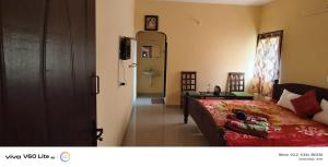 a bedroom with a bed and a door to a bathroom at Sky park homestay in Yercaud