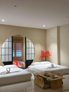 two beds in a room with a mirror at Ipoh Town Hotel by Serenity in Ipoh