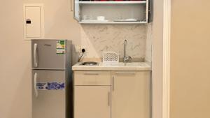 a kitchen with a sink and a refrigerator at Areen Al Naeem Served Apartments in Jeddah