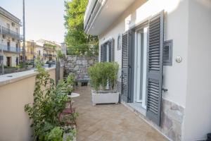 a patio with a table and shutters on a building at La Magnolia in Centola