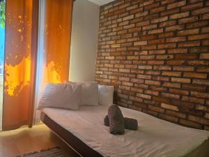 a bed in a room with a brick wall at Przystanek Żarnowska Domki in Żarnowska