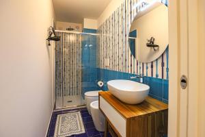 a bathroom with a sink and a toilet and a mirror at Donna Maria Apartments - Amami Collection in Amalfi