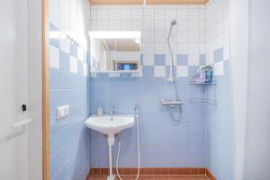 a blue tiled bathroom with a sink and a shower at Kisala, Vuokatti I Huippu sijainti in Vuokatti +19 photos