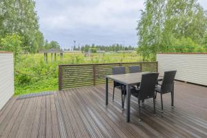a wooden deck with a table and chairs on it at Kisala, Vuokatti I Huippu sijainti in Vuokatti
