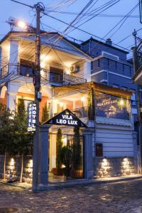 a building with a lit up sign in front of it at Vila Leo Lux in Korçë