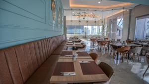 a dining room with wooden tables and chairs at Paseo La Galería Hotel & Suites in Asunción +51 photos