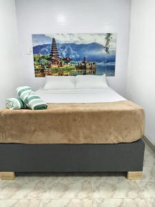 a bed in a room with a picture on the wall at Hospedaje Parque Central frente al parque principal in Santa Rosa de Cabal