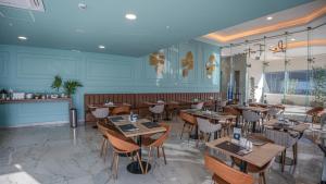 a restaurant with wooden tables and chairs and blue walls at Paseo La Galería Hotel & Suites in Asunción