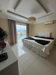 a bedroom with a bed and a large window at Mansão Bolsoni in Saquarema