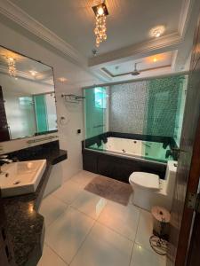 a bathroom with a tub and a toilet and a sink at Mansão Bolsoni in Saquarema