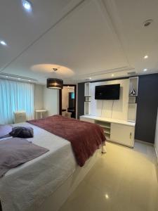 a bedroom with a large bed and a flat screen tv at Mansão Bolsoni in Saquarema +26 photos