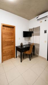 a room with a table and a chair and a door at Casa Bugambilias in Tenosique de Pino Suárez