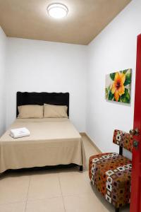 a bedroom with a bed and a chair in it at Casa Bugambilias in Tenosique de Pino Suárez +5 photos