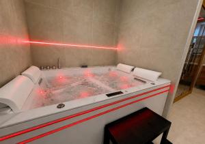 a hot tub in a room with red lights at Spa Privatif Montataire in Montataire