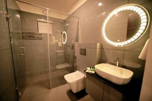 a bathroom with a sink and a toilet and a mirror at LUMARISE Hotel in Sultan Bathery