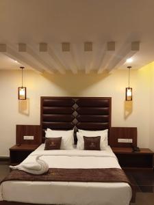 a bedroom with a large bed with two pillows at LUMARISE Hotel in Sultan Bathery