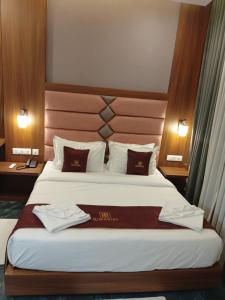 a hotel room with a bed with two towels on it at LUMARISE Hotel in Sultan Bathery