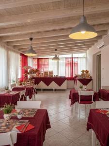 a restaurant with red tables and white chairs and red curtains at La locanda di Gioele in Lido di Camaiore