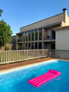a swimming pool with a pink float in the water at Can 28 in Torroella de Montgrí