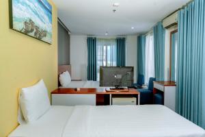 a hotel room with two beds and a desk at Rico hotel Nha Trang in Nha Trang