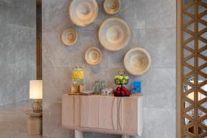 a table with fruit and baskets on a wall at Radisson Blu Resort, Phuket Mai Khao Beach in Mai Khao Beach