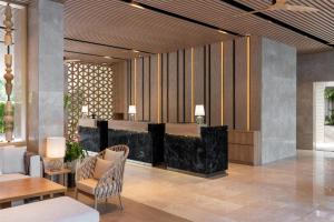 a lobby with a bar and a table and chairs at Radisson Blu Resort, Phuket Mai Khao Beach in Mai Khao Beach