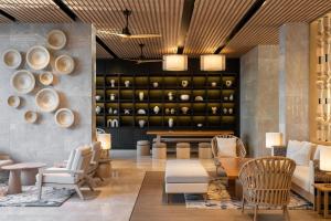 a room with a table and chairs and a shelf with bowls at Radisson Blu Resort, Phuket Mai Khao Beach in Mai Khao Beach