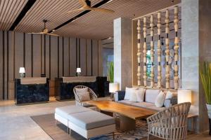 a lobby with a couch and a table and chairs at Radisson Blu Resort, Phuket Mai Khao Beach in Mai Khao Beach