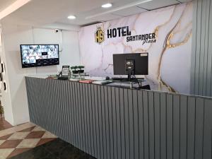 a lobby of a hotel with a computer on the counter at Hotel Santander Plaza in Neiva