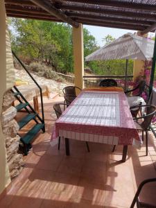 a table and chairs on a patio with an umbrella at Casa do Castelão in Loulé