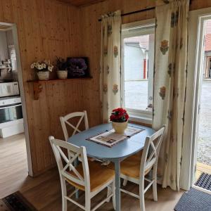 a dining room with a table and chairs and a window at Svenningdal Camping in Svenningdal