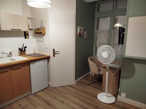 a kitchen with a white refrigerator and a fan at Le Petit Jean Alexandre – Studio centre-ville in Poitiers