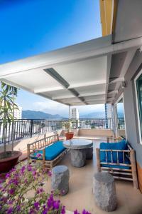 a patio with a table and benches on a balcony at Rico hotel Nha Trang in Nha Trang