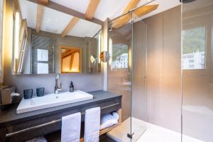 a bathroom with a sink and a shower at Hotel Albris in Pontresina +67 photos