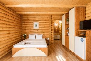 a bedroom with a bed in a wooden room at Ensenada in Gribovka