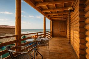 a wooden deck with a table and chairs on the beach at Ensenada in Gribovka +14 photos