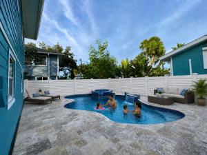 a family playing in a pool in a backyard at Sand Dollar Suite by Sun Palace Vacations in Fort Myers Beach