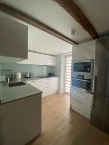 a kitchen with white appliances and a wooden floor at Earra - Salegi - 2 minutos playa in Zarautz