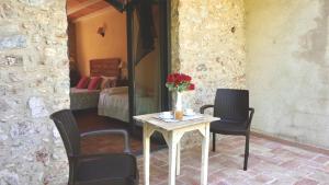 a table with chairs and a vase of flowers on it at Can 28 in Torroella de Montgrí