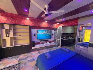 a bedroom with a blue bed and a flat screen tv at weston Hotel And Resorts in kolkata