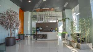 an office lobby with a reception desk and potted plants at Paseo La Galería Hotel & Suites in Asunción