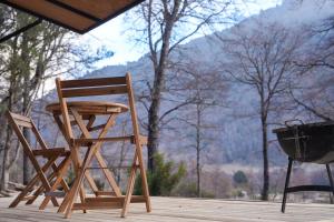 a wooden rocking chair and a grill on a deck at Tagua Cabins Malalcahuello in Malalcahuello +5 photos