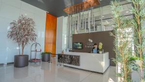 a lobby with a reception desk and potted plants at Paseo La Galería Hotel & Suites in Asunción