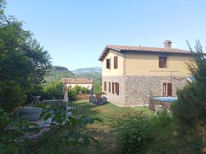 a stone house with a yard with a pool at Il Gelso Rosso in Comunanza