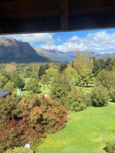 a view of a park with trees and mountains at Arelauquen Bungalows & Suites in San Carlos de Bariloche