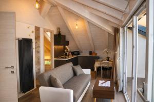 a living room with a couch and a table at White suite - Jacuzzi, Swimming pool & Lake view in Lezzeno