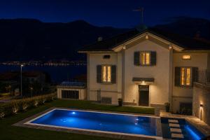 a villa with a swimming pool in front of a house at White suite - Jacuzzi, Swimming pool & Lake view in Lezzeno