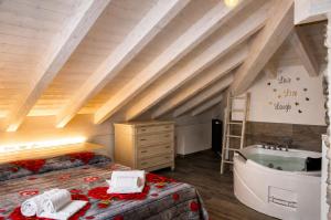 a attic bedroom with a bath tub and a bed at White suite - Jacuzzi, Swimming pool & Lake view in Lezzeno +24 photos